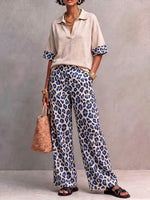Women's Two-piece Set Featuring A Casual Loose-fitting Short-sleeved Collared Pullover Top And High-waisted Loose-fitting Wide-leg Trousers With A Leopard Print.